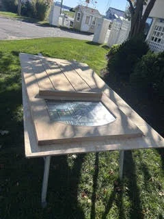 Wood entry door with decorative glass laid on supports before installation